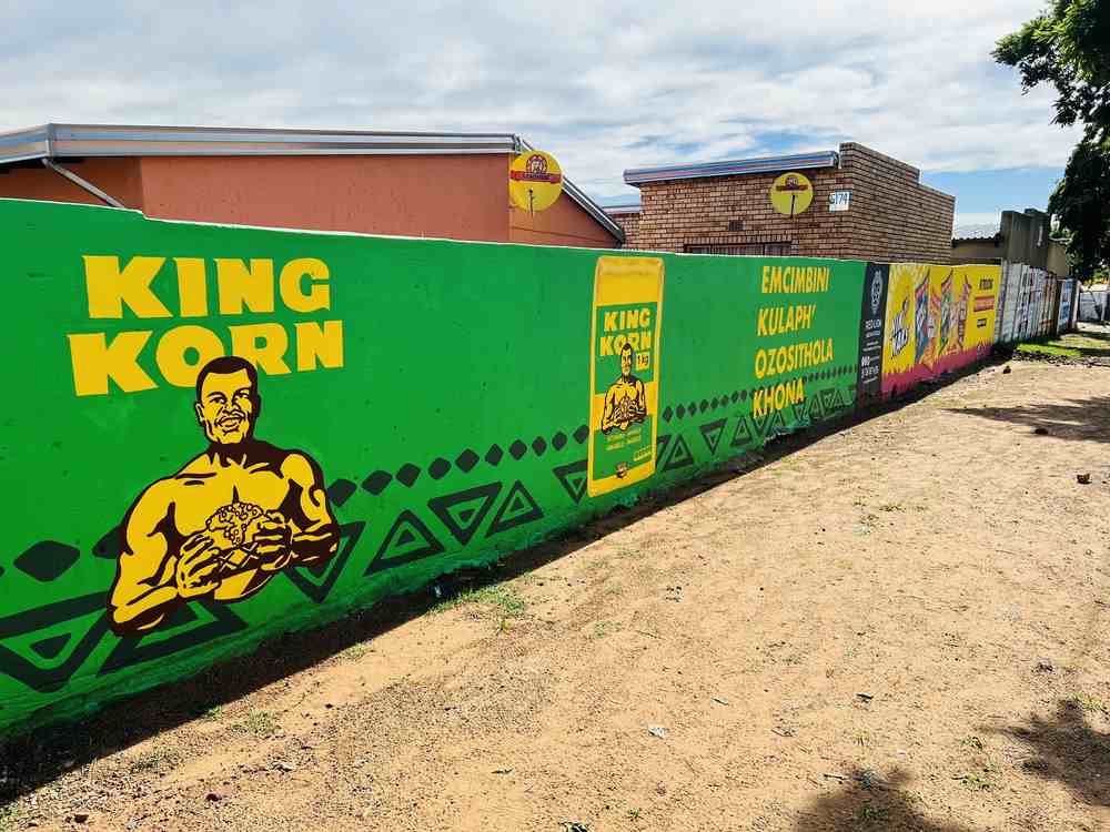 Green King Korn mural with heritage figure and vernacular copy